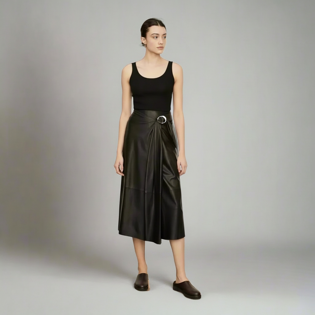 Woman wearing a black sleeveless top and black leather skirt on a gray background
