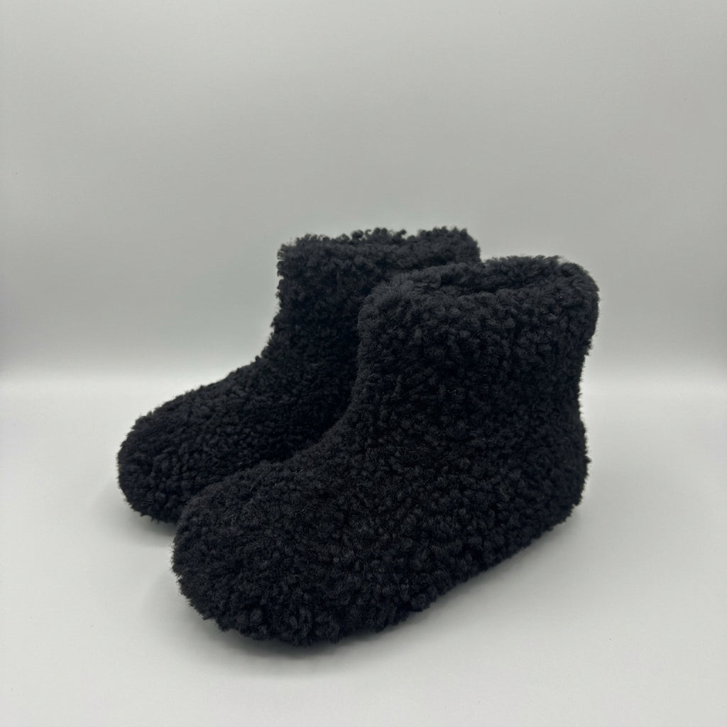 black curly shearling ankle boots, three-quarter view of the pair
