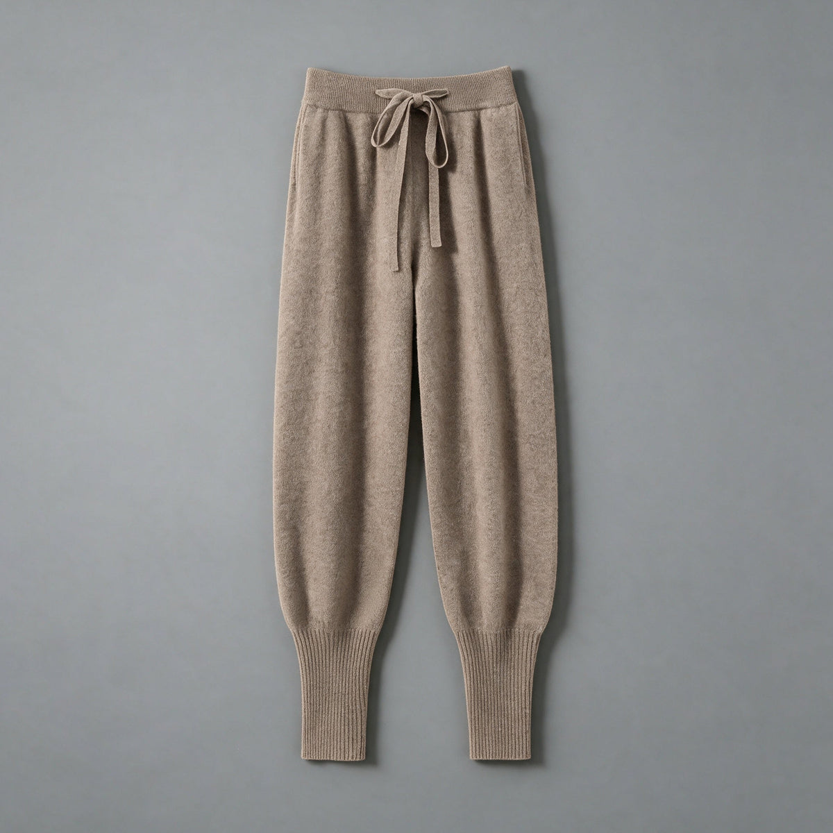 Cashmere drawstring trousers in brown, front view, on a grey studio backdrop