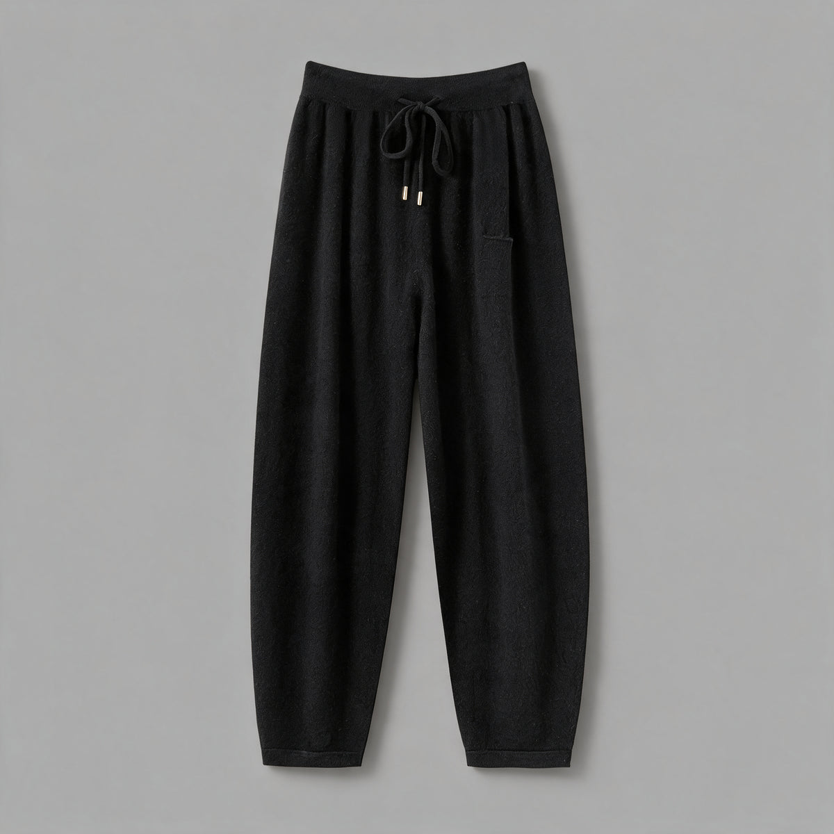 Cashmere joggers in black, front view, on a grey studio backdrop