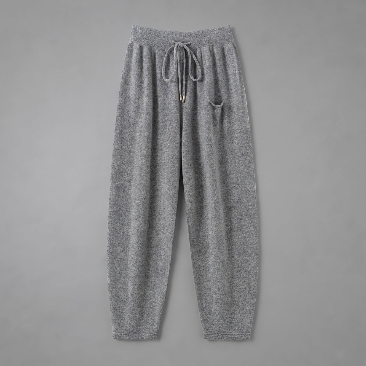 Cashmere joggers in grey, front view, on a grey studio backdrop