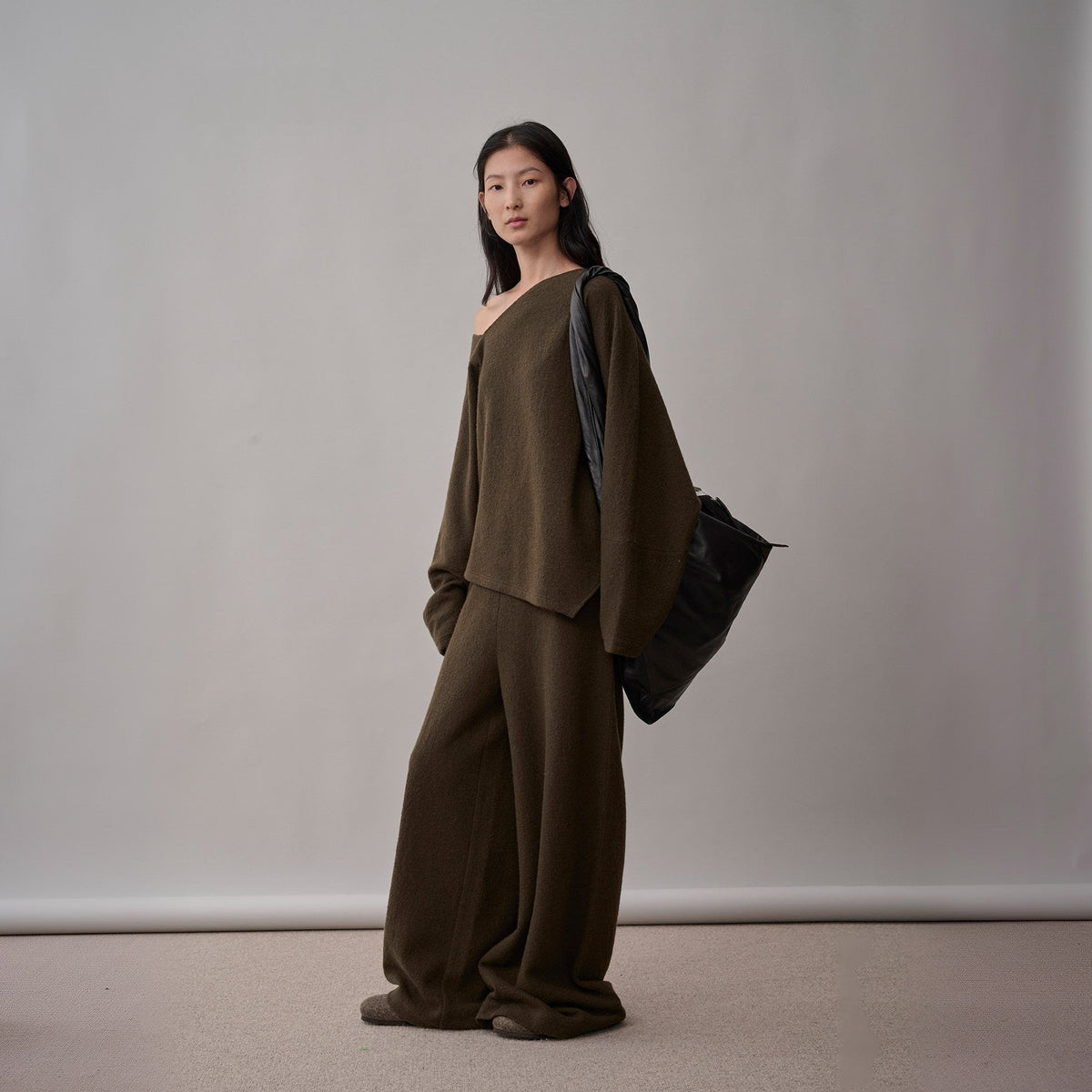 Dark brown wool sweater and wide-leg pants set, three-quarter front view on model, side slit at the hem