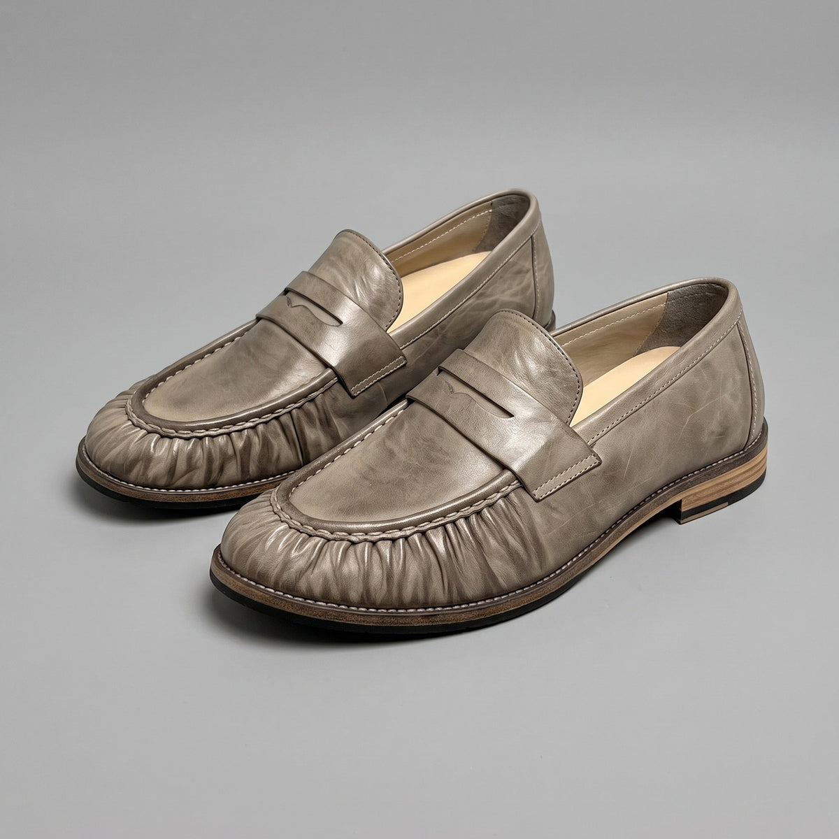 Truffle penny loafers in washed horsehide, pair at an angle