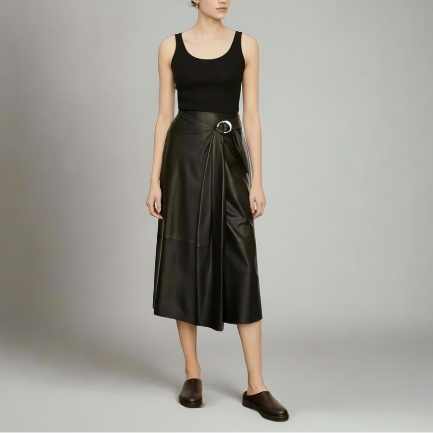 Woman wearing a black sleeveless top and black leather skirt on a gray background