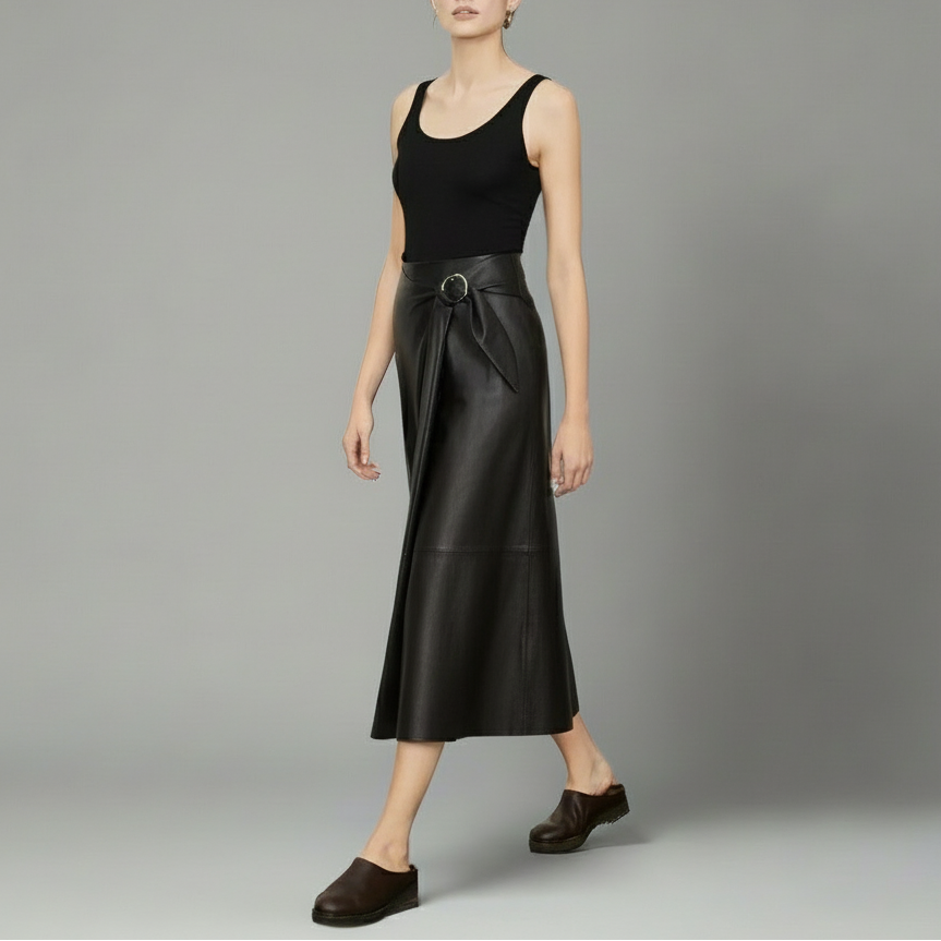 Woman wearing a black sleeveless top and leather skirt on a gray background