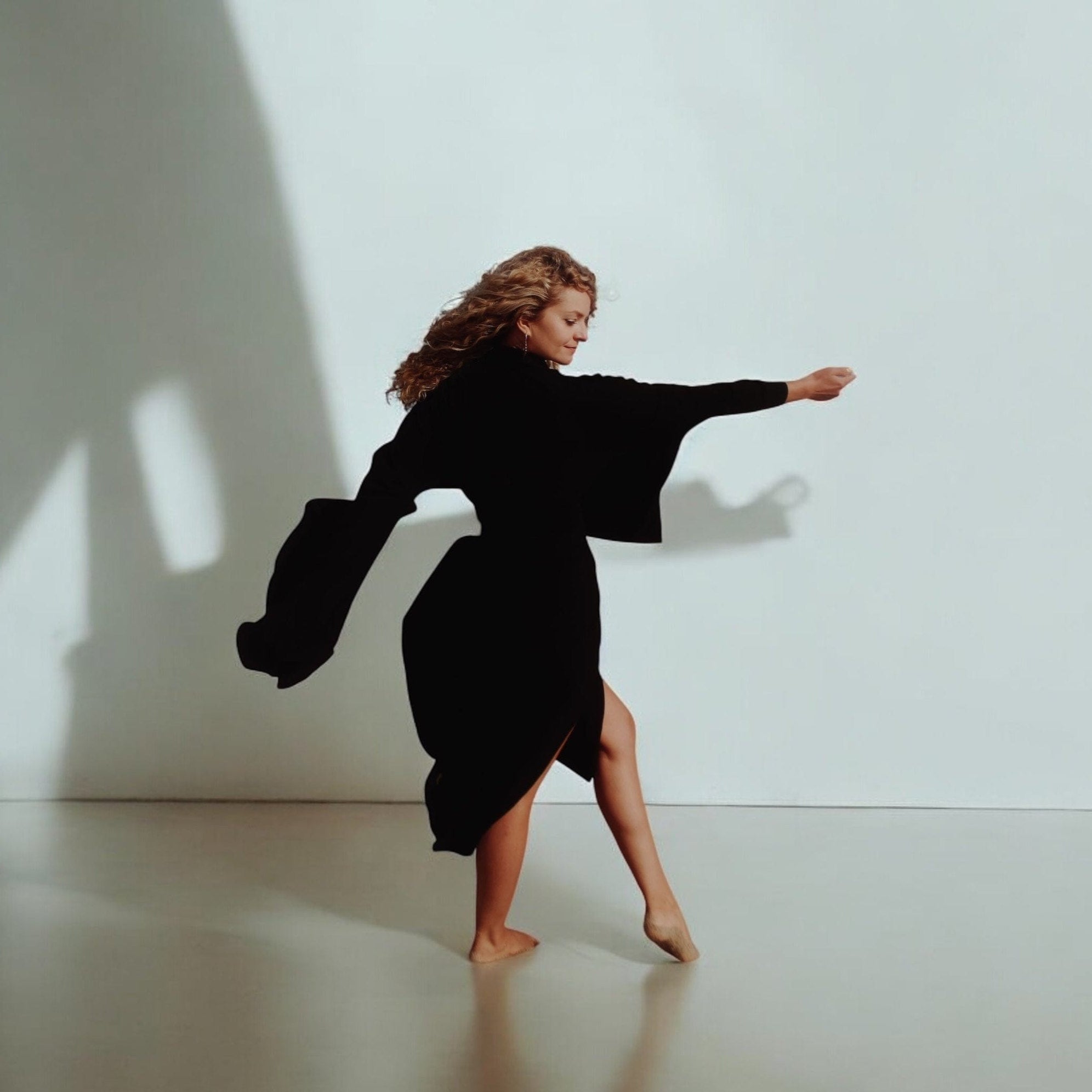 Full-length view of the modern black kimono with oversized pockets and a sturdy belt.
