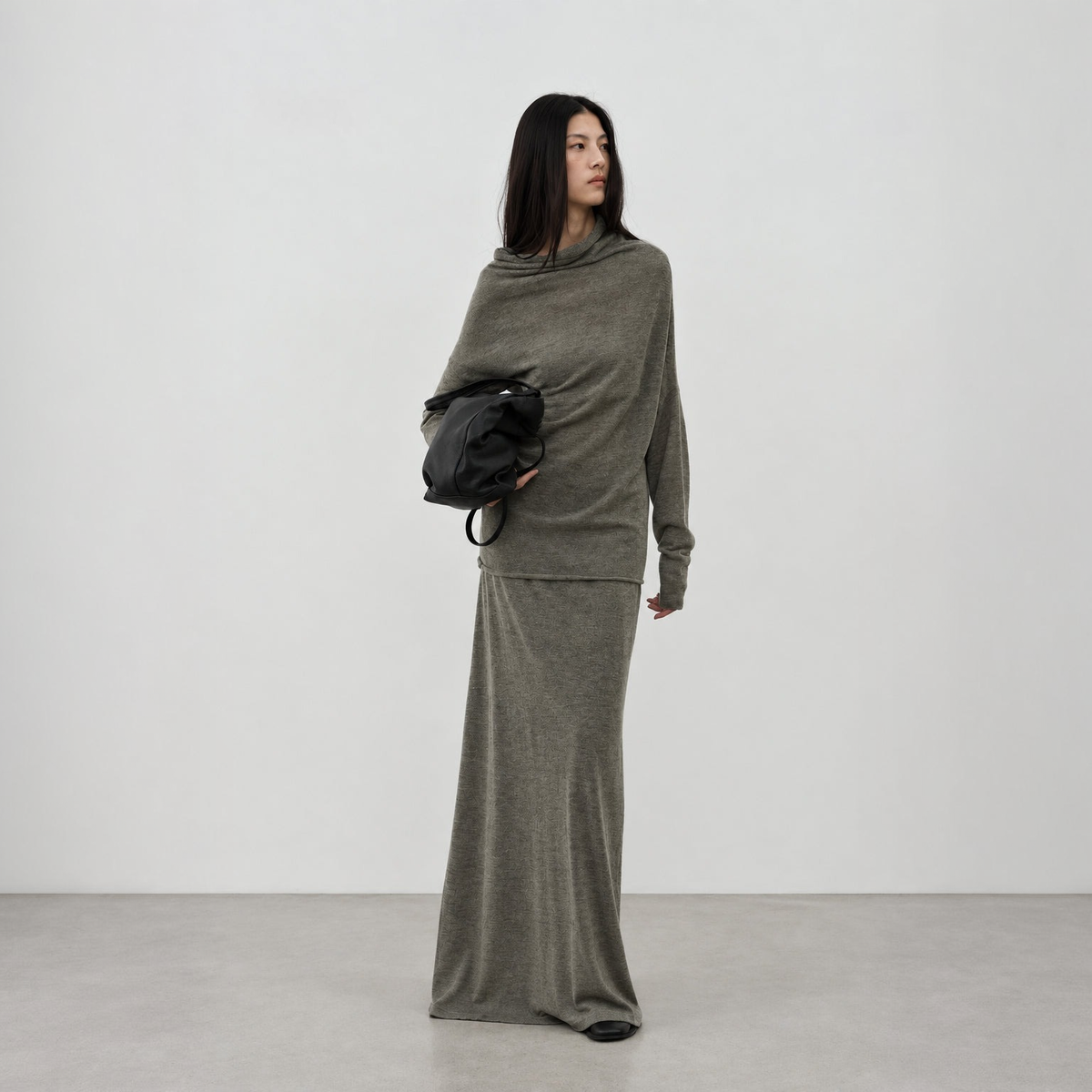 Alpaca cowl neck sweater and long skirt set in brown, full-length front view on model holding a black bag