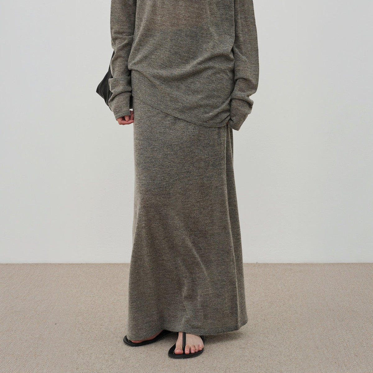 Brown long knit skirt worn with the sweater, view from chest to floor on model