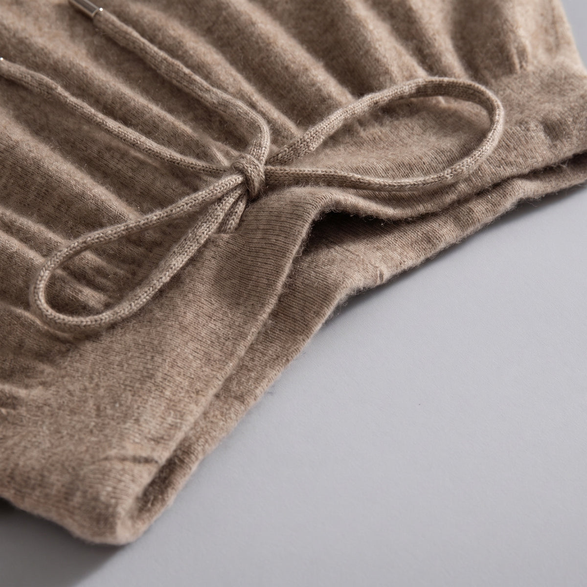 Cashmere joggers in brown, waist and drawstring detail, on a grey studio backdrop