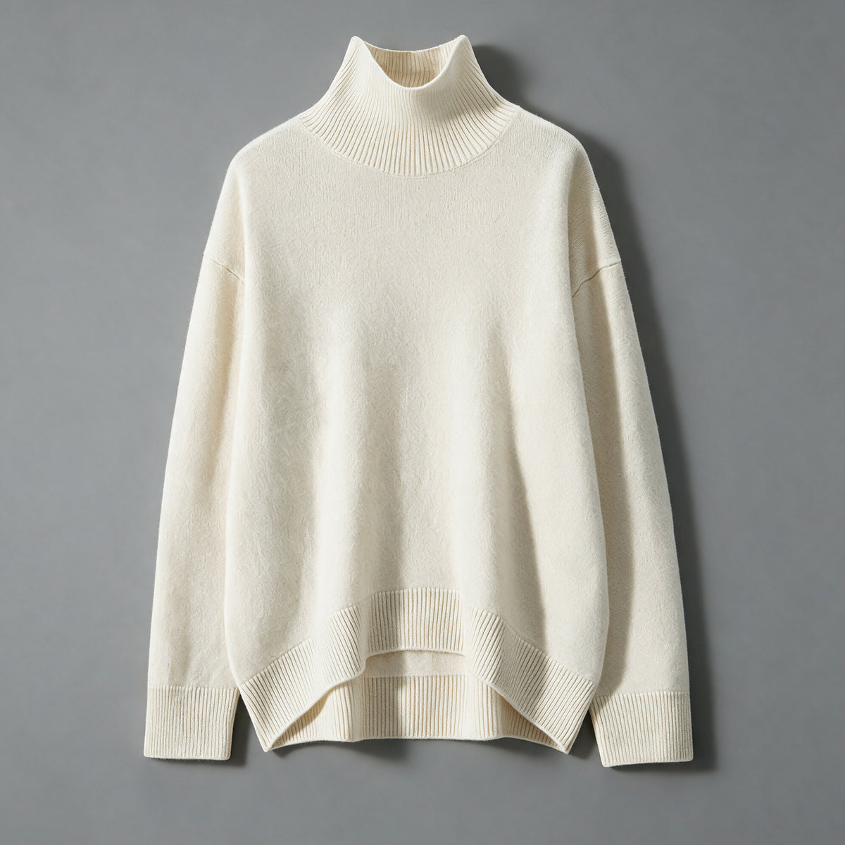 White cashmere turtleneck sweater, front view, ribbed cuffs and a curved ribbed hem