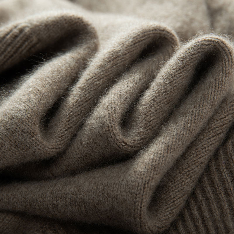Folded knit of a brown cashmere turtleneck sweater, close-up of the fabric