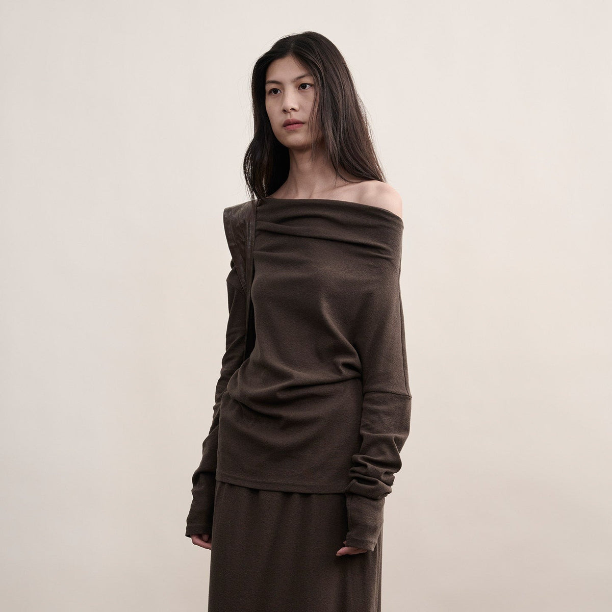 Brown cotton one-shoulder top with long sleeves, front view on model from head to hip