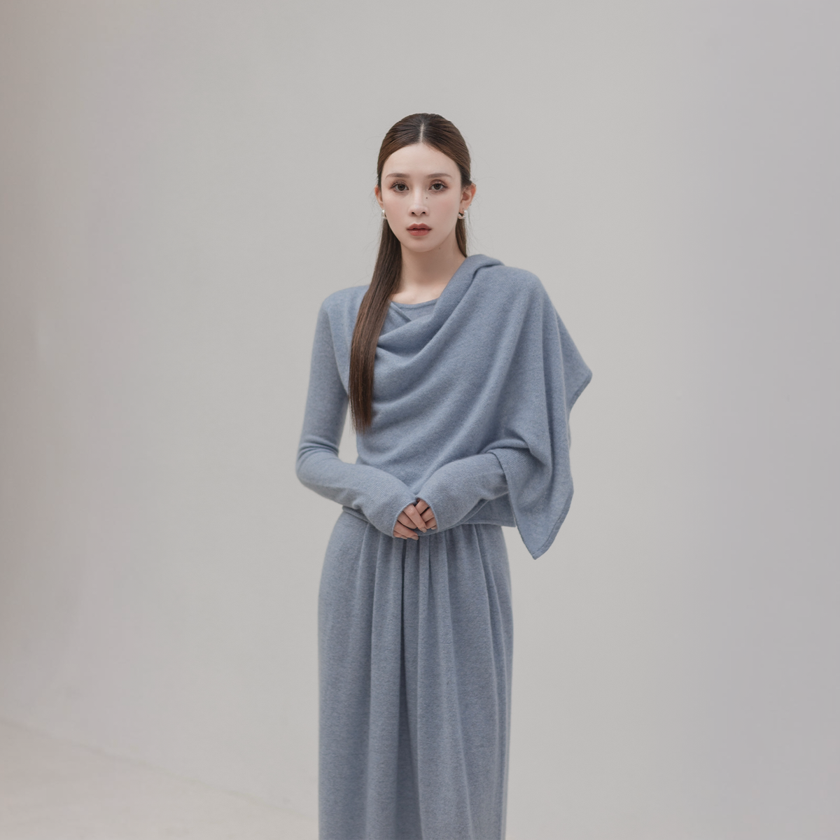 Scarf cape top and knit skirt set in grey-blue, front view on model with the cape draped over the shoulders in folds