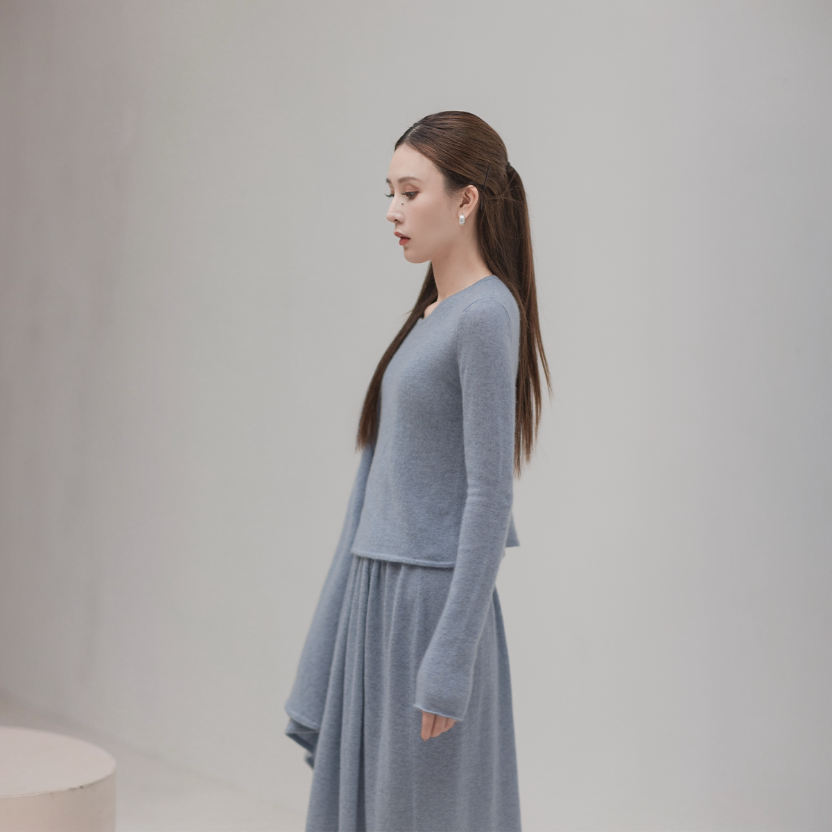 Scarf cape top and knit skirt set in grey-blue, side view on model with the cape hanging at the front
