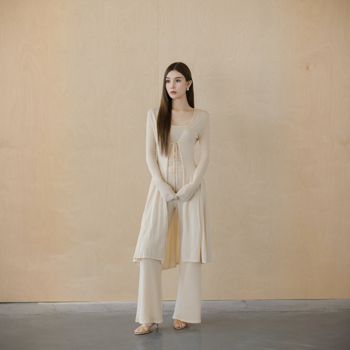 Cream V-neck tie-front cardigan, front view on model, tied in a small bow at the base of the V