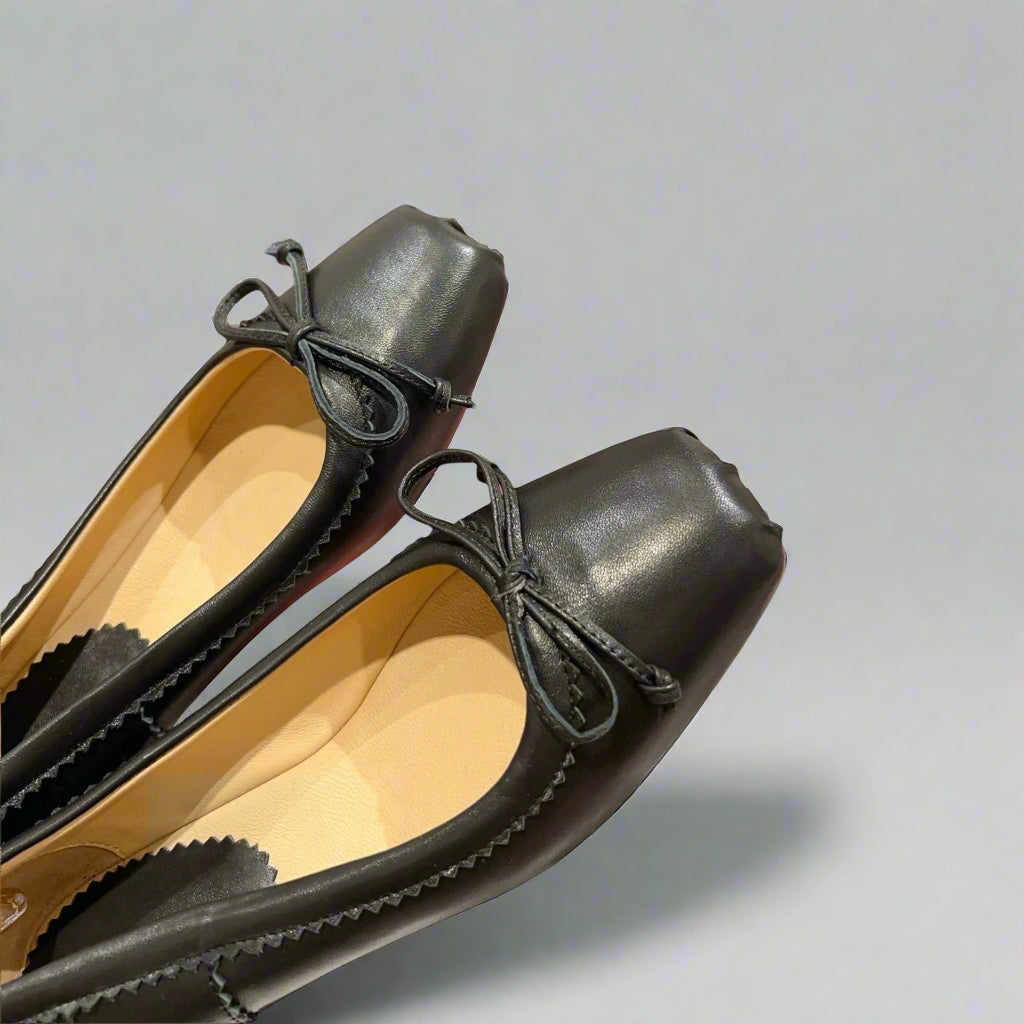 Classic ballerina flats with a structured square toe and delicate bow accent.