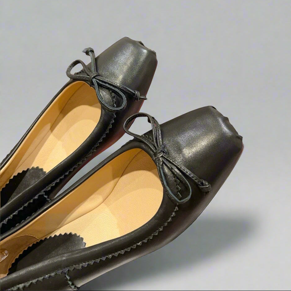 Classic ballerina flats with a structured square toe and delicate bow accent.