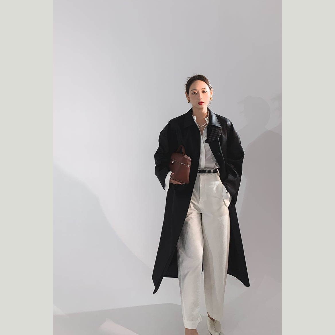black trench coat shown with womens clothing