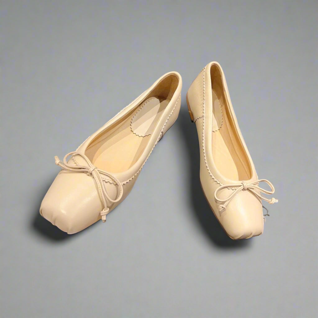 Classic ballerina flats with a structured square toe and delicate bow accent.
