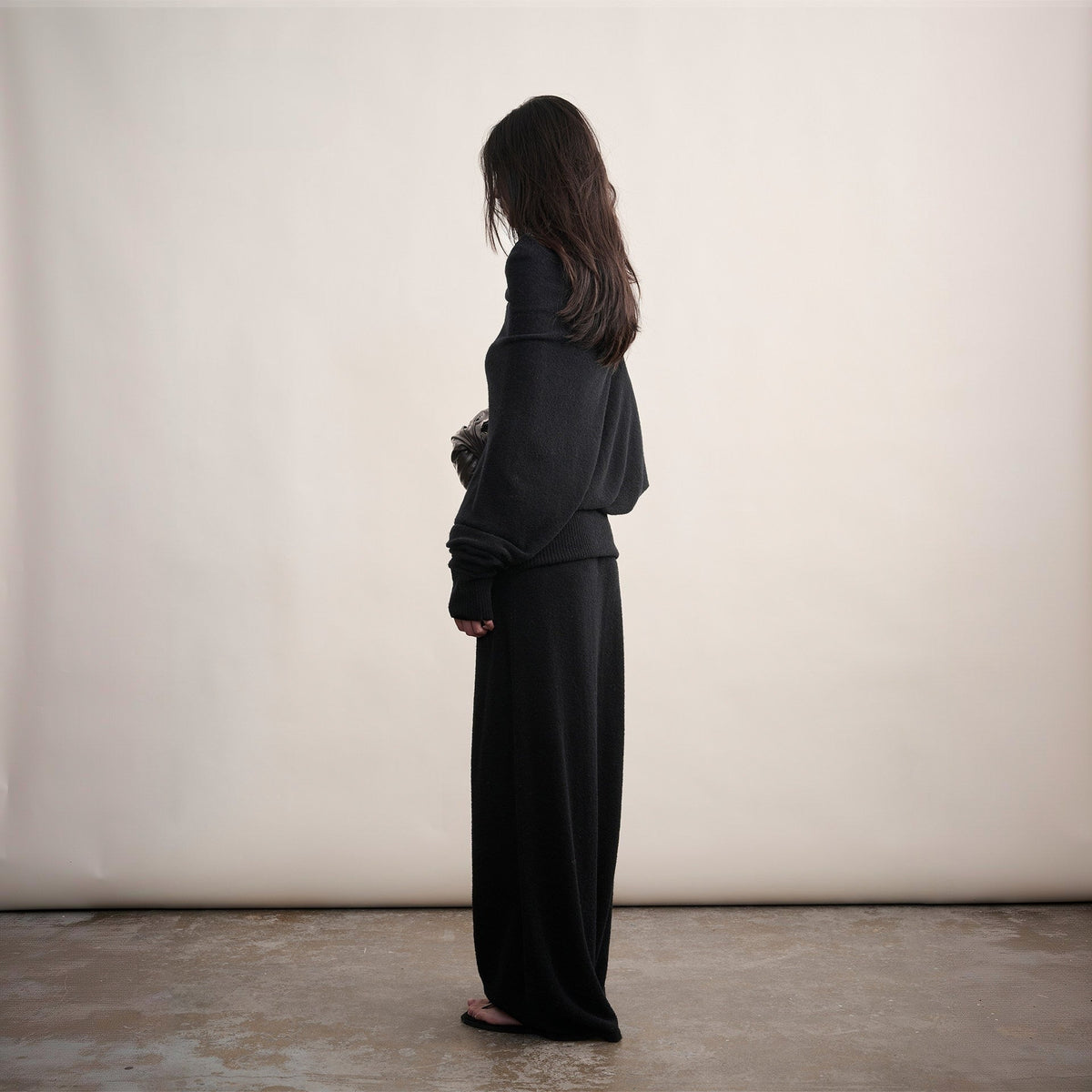 Black off-shoulder wool sweater and long skirt set, side view on model