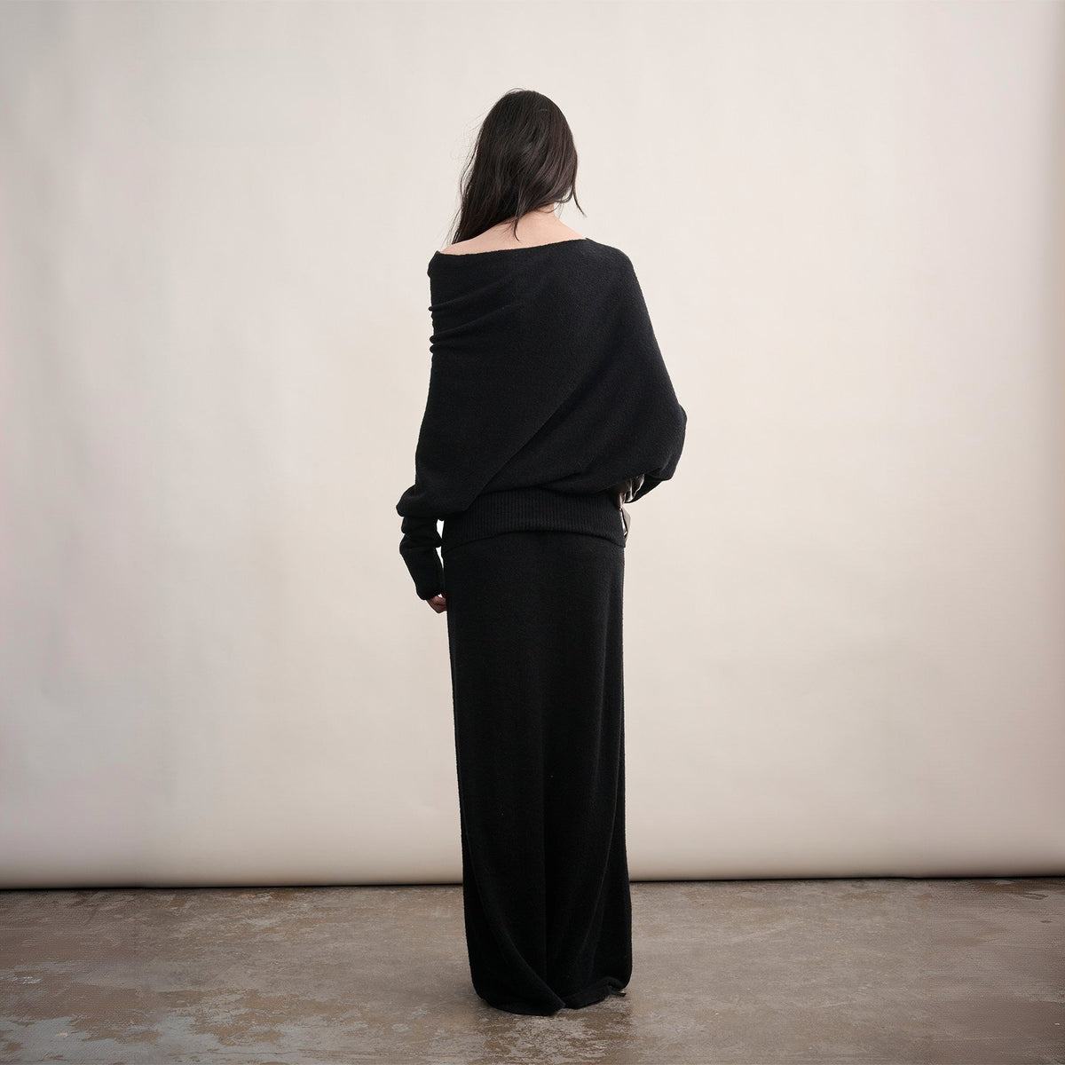 Black off-shoulder wool sweater and long skirt set, back view on model