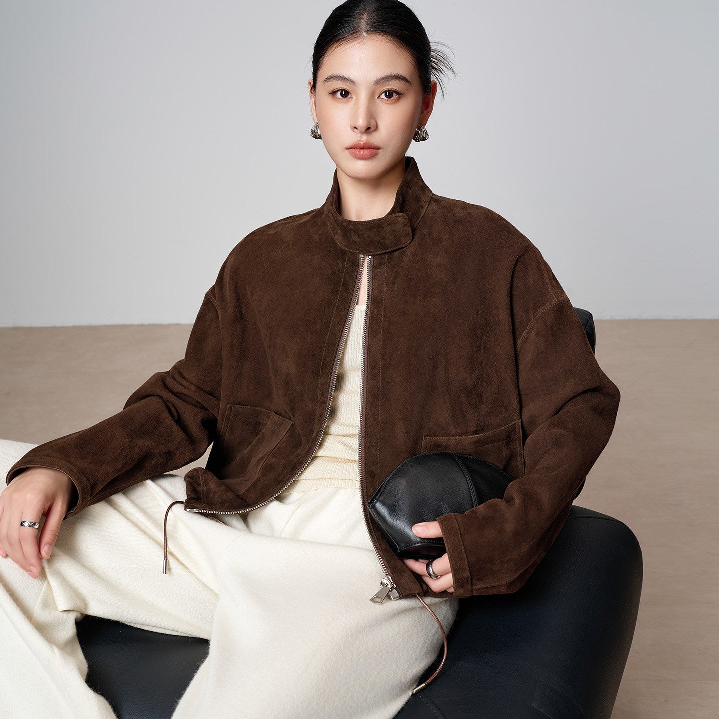 Close-up texture detail of the brown suede funnel-neck jacket