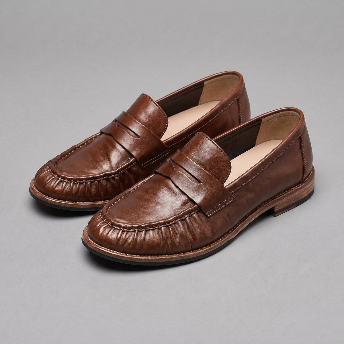 Chestnut penny loafers in washed horsehide, pair at an angle